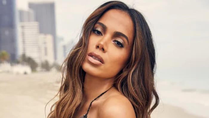 Anitta stands on the beach in a bikini and poses for the camera.